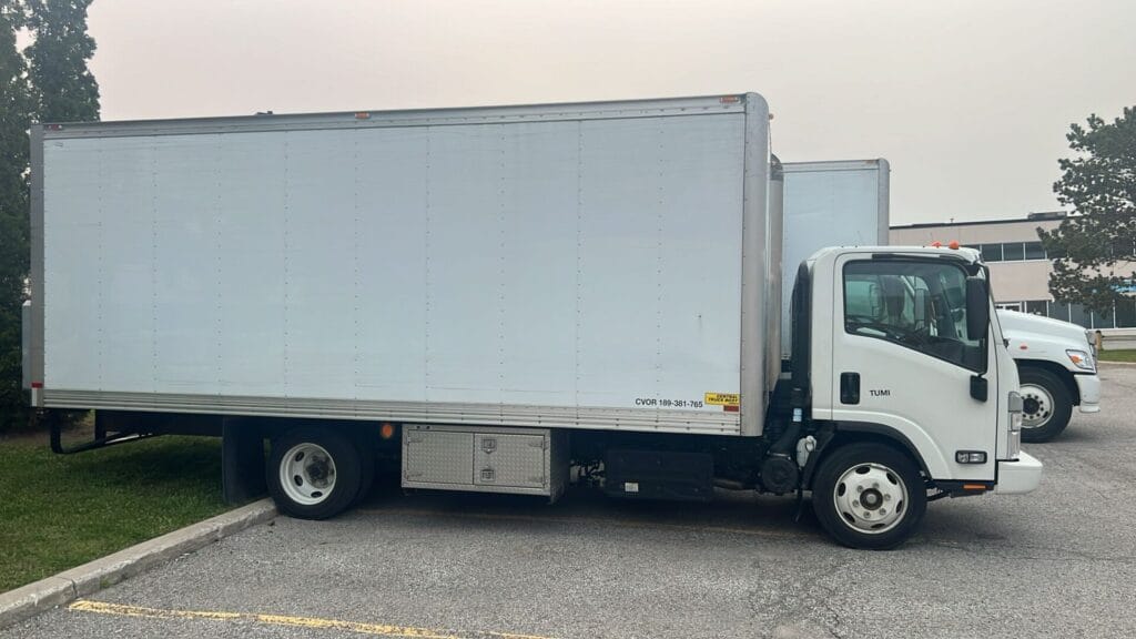 Side view of a 20ft white moving truck parked in a Toronto lot, used for apartment and condo moves