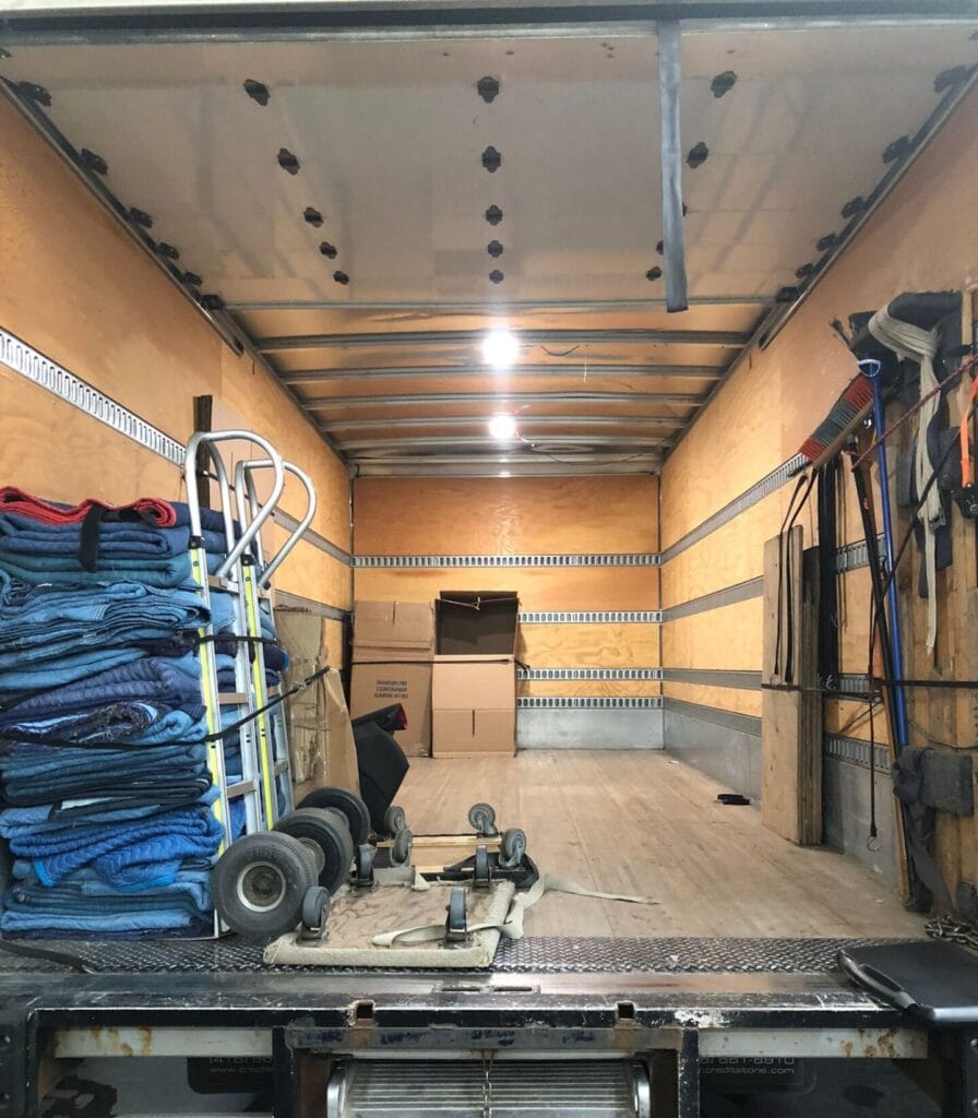 Interior view of a moving truck showing moving blankets, dollies, straps, and tools organized for a residential move in Toronto