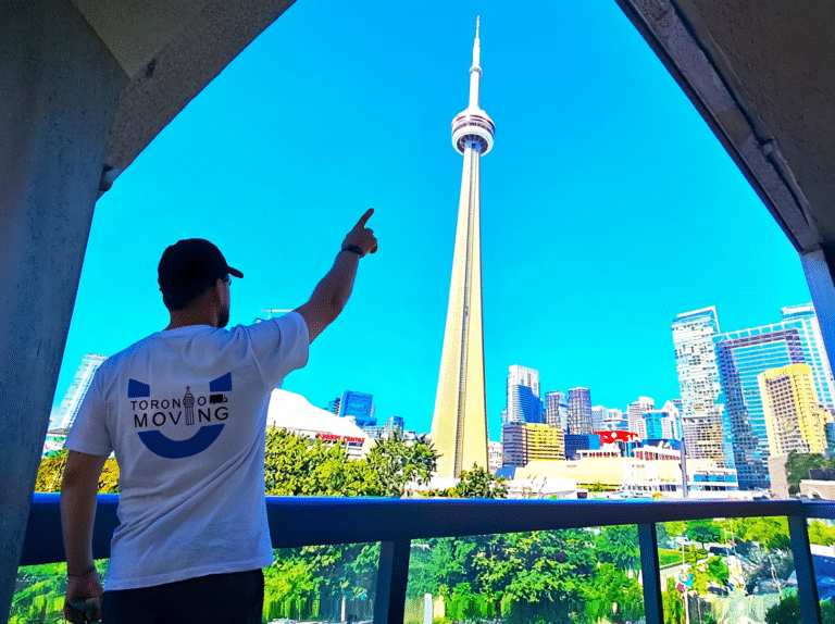 Toronto Moving team member pointing at CN Tower from downtown condo balcony