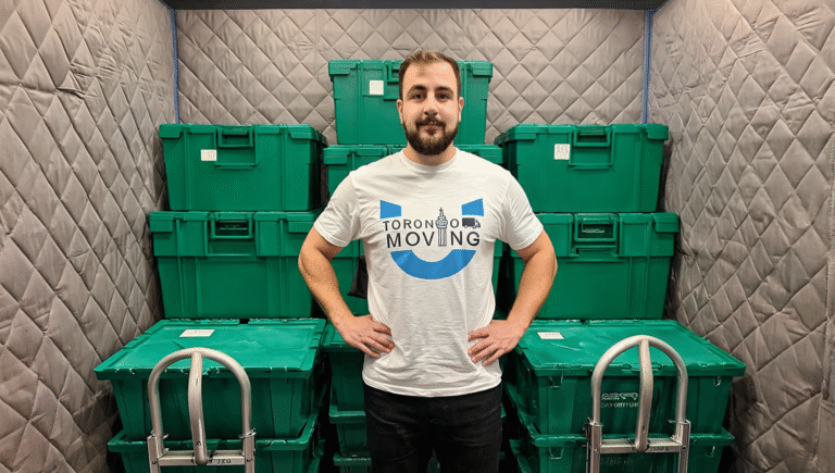 Toronto Unique Moving staff member standing confidently in a padded service elevator with green moving bins